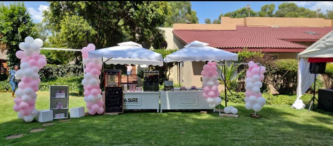 Styled outdoor sweet cart setup with balloon arches